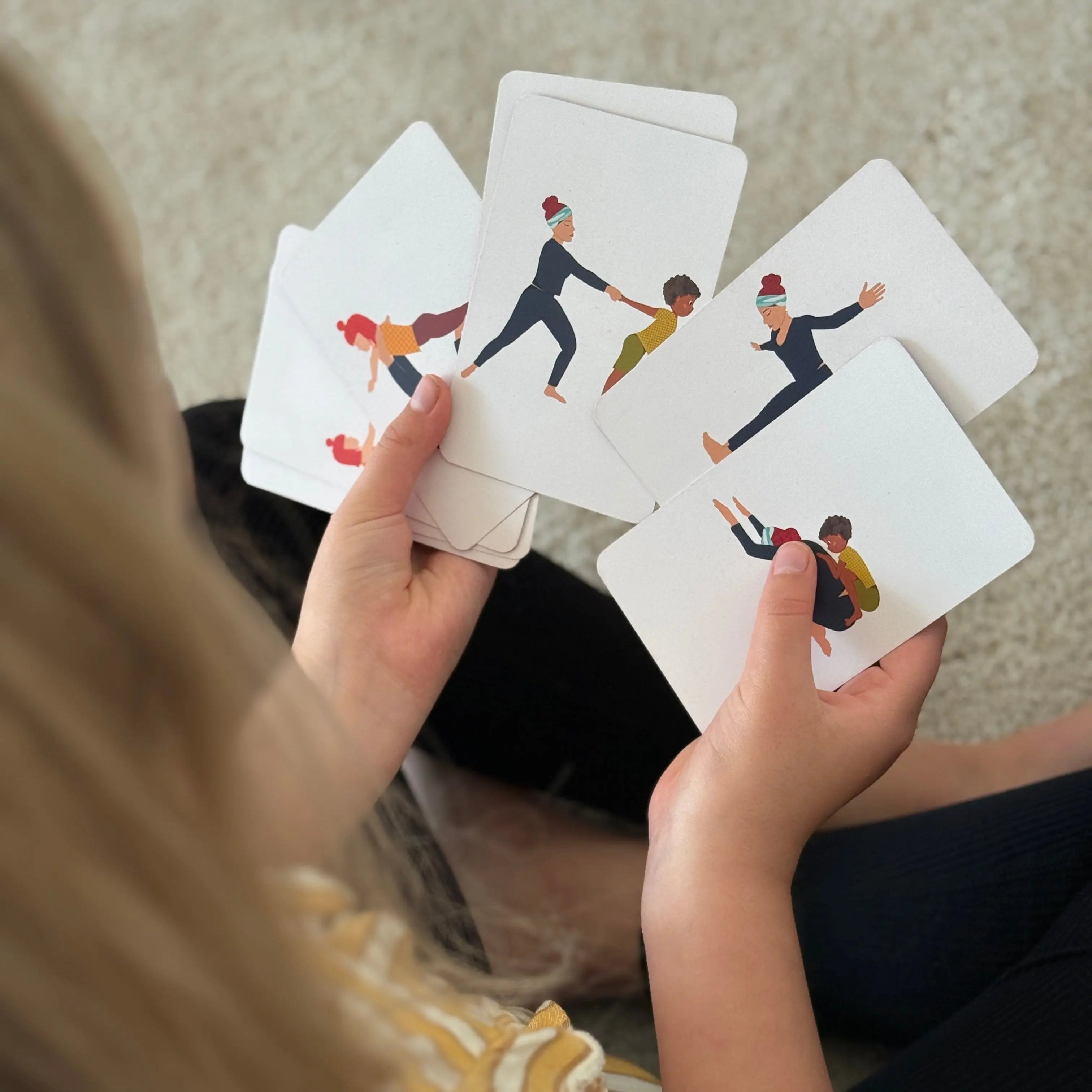 kind houdt de yoga kaarten van Full of yoga in haar handen, klaar om te spelen.